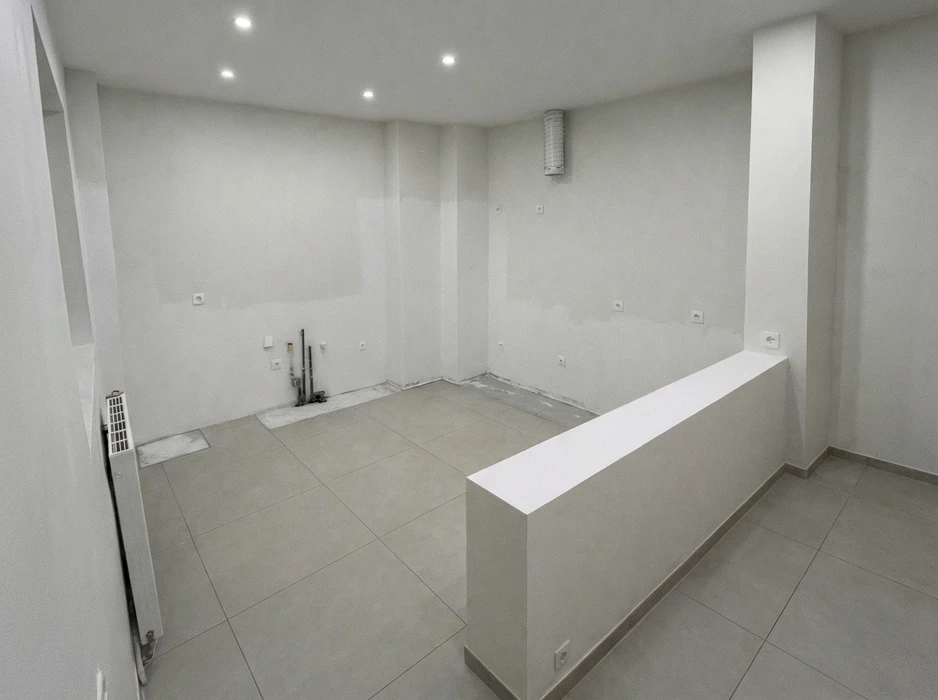 Salon moderne avec meuble TV suspendu blanc et bois, étagères géométriques blanches servant de cloison, parquet chêne massif, plafond avec faux-plafond bois